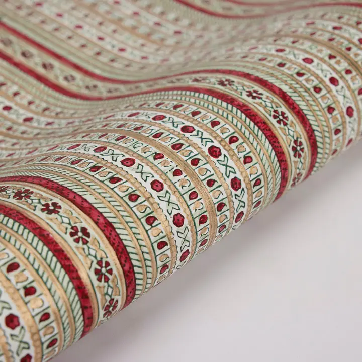 Papel de regalo artesanal grabado a mano con diseño de navidad rojo, verde y dorado de Jabón y Papel.